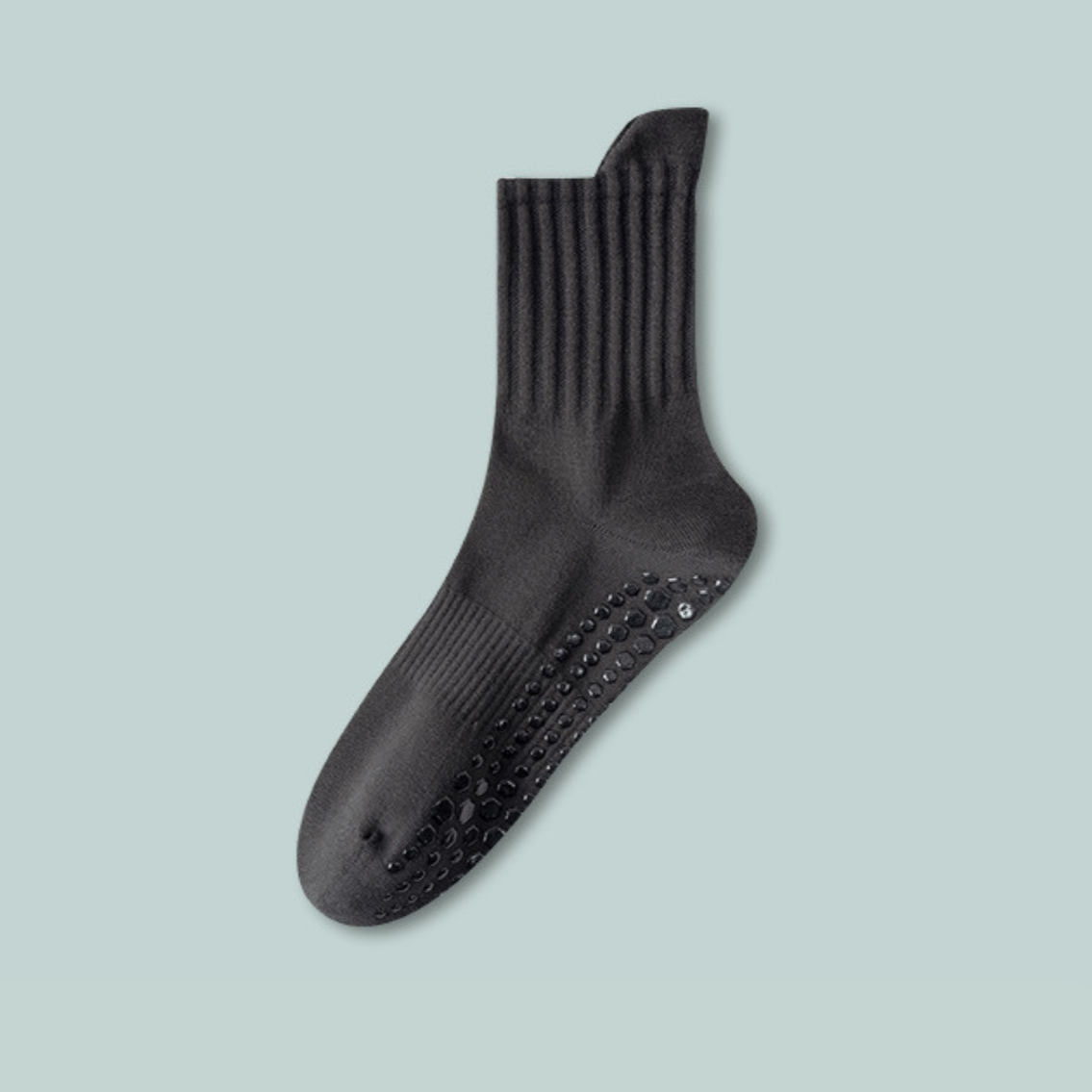 Black sock with textured sole on a light blue background